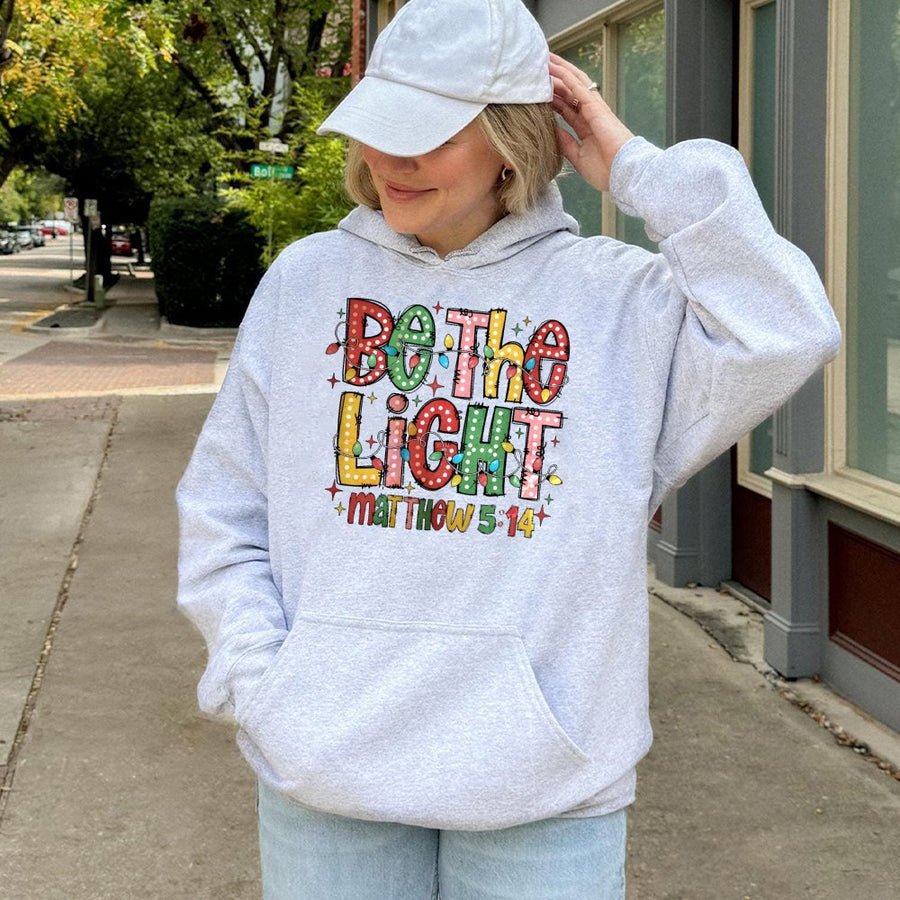 Be The Light Matthew 5:14 Hoodie | Festive Christmas Lights Graphic | Cotton-Blend Comfort | Christian Gift for Faith-Inspired Holiday Apparel