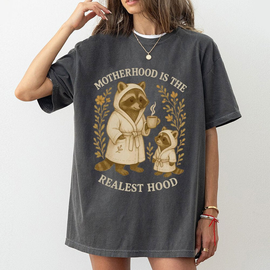 Motherhood Is The Realest Hood T-Shirt | Cute Raccoon Mom and Baby Graphic | Premium 100% Cotton Tee | Funny Mother's Day 2026 Gift for New Mom
