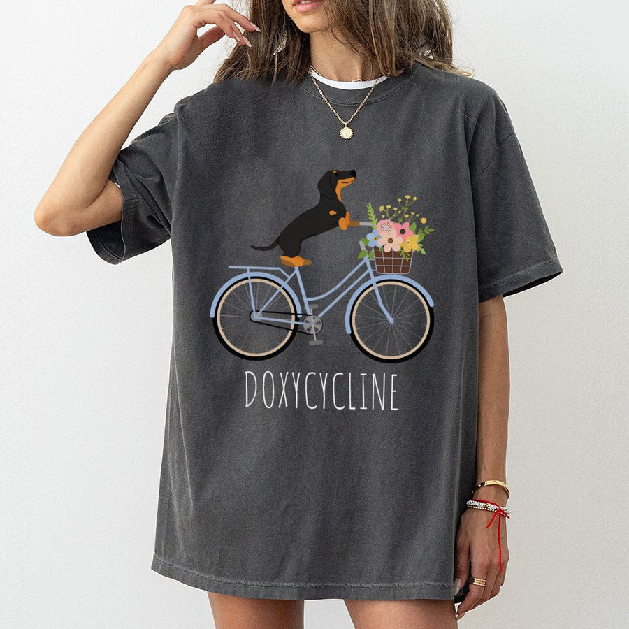 Dachshund Bicycle T-Shirt | Doxycycline Pharmacy Pun Graphic | Premium Cotton Unisex Tee | Gift for Pharmacists Pharmacy Techs