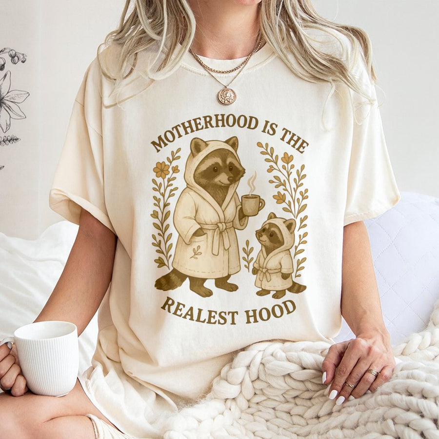 Motherhood Is The Realest Hood T-Shirt | Cute Raccoon Mom and Baby Graphic | Premium 100% Cotton Tee | Funny Mother's Day 2026 Gift for New Mom