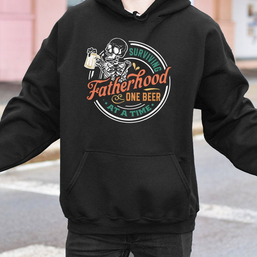 Surviving Fatherhood One Beer At A Time Hoodie | Funny Skeleton Dad Graphic | Premium Cotton Blend | Best Father's Day 2026 Gift For New Dad
