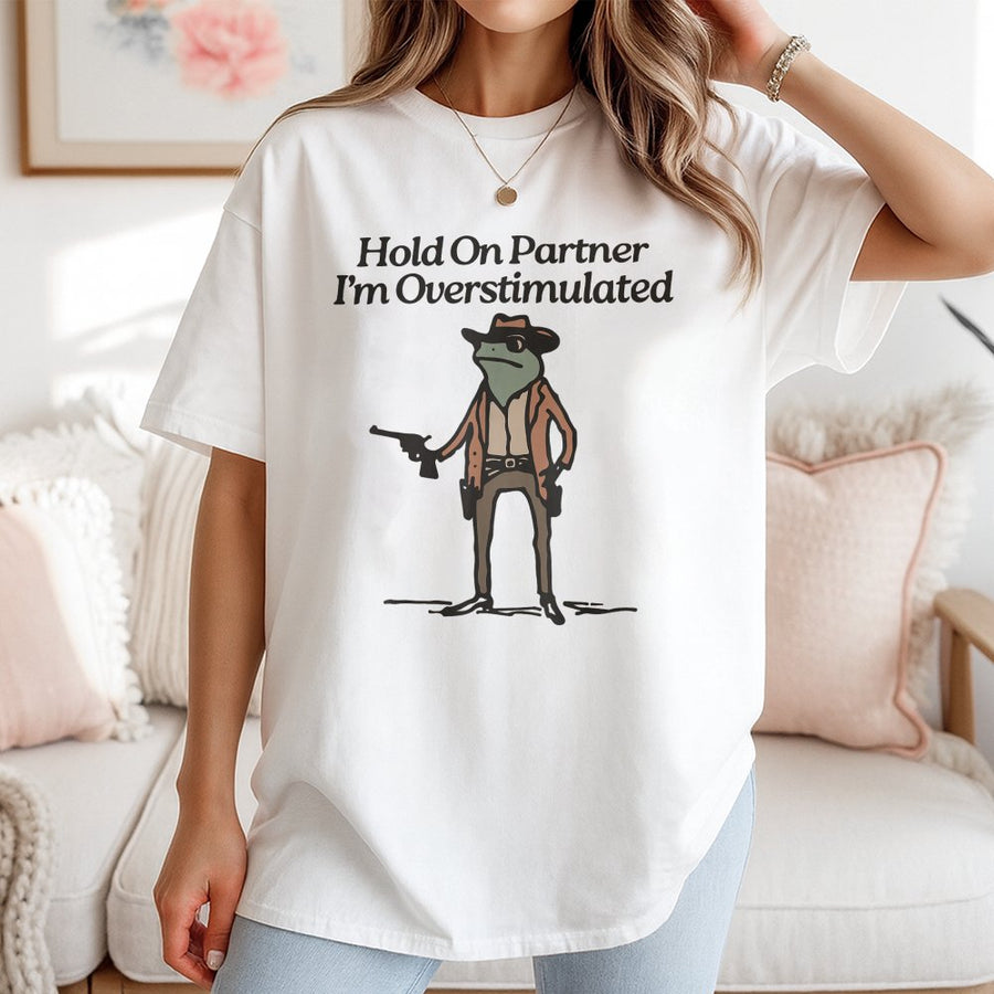 Hold On Partner I'm Overstimulated Frog T-Shirt | Funny Cowboy Toad Graphic Tee | 100% Cotton Premium Quality | Gift for Introverts & Meme Lovers