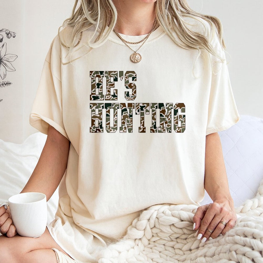 He's Hunting T-Shirt | Camouflage Varsity Lettering Print | 100% Premium Cotton | Funny Deer Hunter Gift for Him