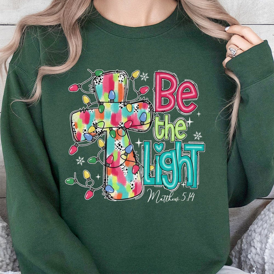 Be The Light Sweatshirt | Christmas Cross Bible Verse Design | Premium Cotton Blend | Faith-Based Holiday Gift for Women and Men