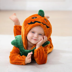 Child lying down in the pumpkin romper, hood up