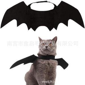 Cat wearing black felt bat wings, side view