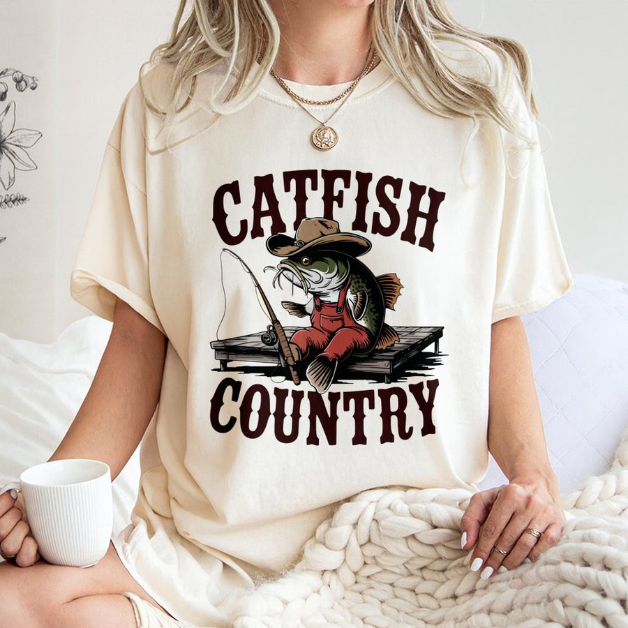 Catfish Country Fishing T-Shirt | Funny Cowboy Catfish Cartoon Graphic | 100% Cotton Premium Tee | Unique Angler Gift for Men and Women