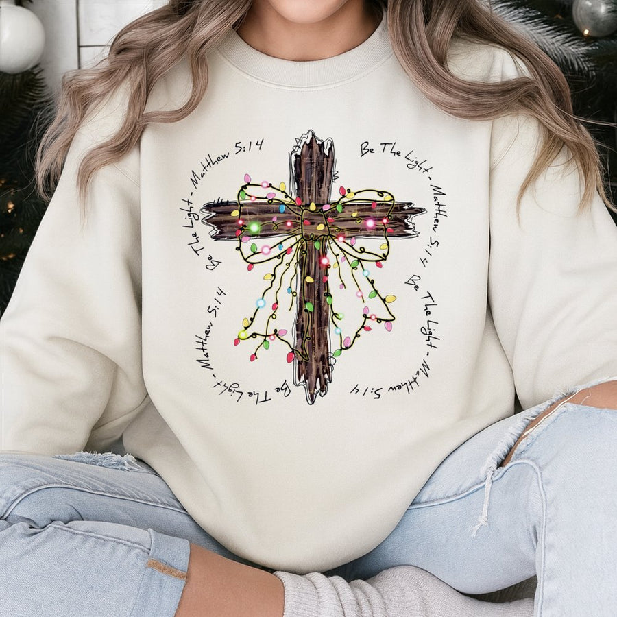 Be The Light Sweatshirt | Rustic Christmas Cross with Lights | Premium Cotton Blend | Christian Bible Verse Gift for Women and Men