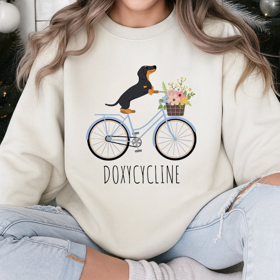 Doxycycline Pharmacy Pun Sweatshirt | Cute Dachshund Riding Bicycle Graphic | Premium Cotton Blend | Funny Gift for Pharmacists and Vet Techs