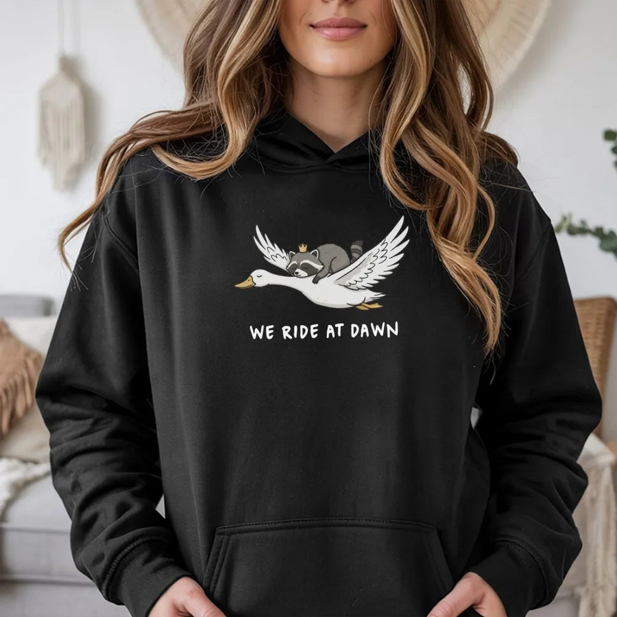 We Ride At Dawn Hoodie | Funny Raccoon Riding Goose Graphic | Premium Cotton Blend Pullover | Cute Animal Lover Gift For Men And Women