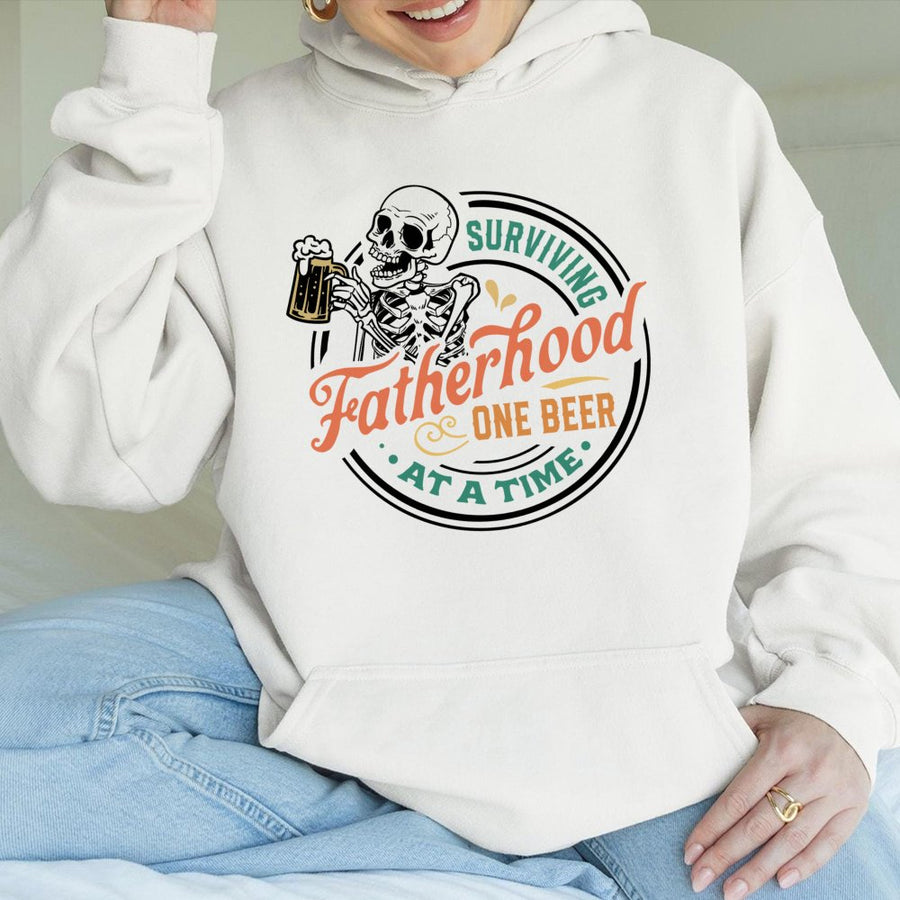 Surviving Fatherhood One Beer At A Time Hoodie | Funny Skeleton Dad Graphic | Premium Cotton Blend | Best Father's Day 2026 Gift For New Dad