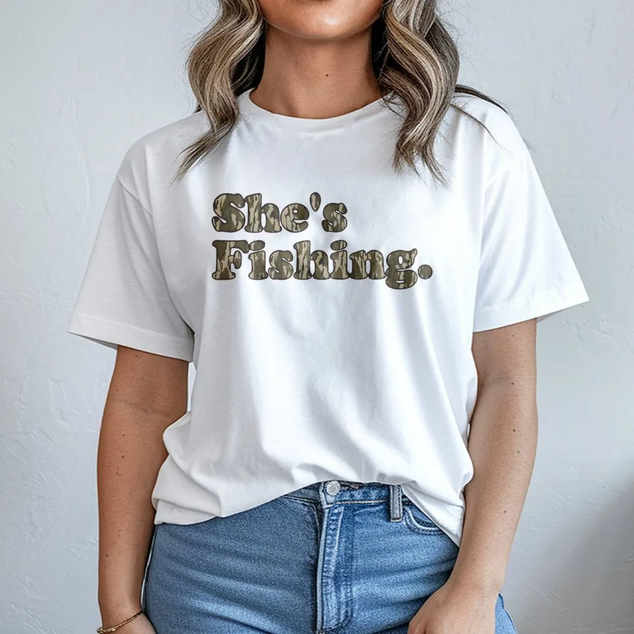 She's Fishing Camo T-Shirt | Retro Woodland Font Design | Premium 100% Cotton | Women's Outdoor Apparel and Fishing Gift for Her