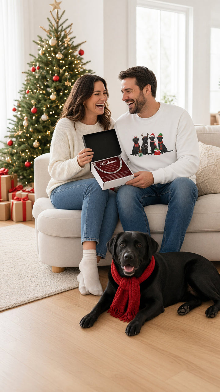 Couple opening a chain necklace gift by the Christmas tree, man in a black Labrador Christmas sweatshirt
